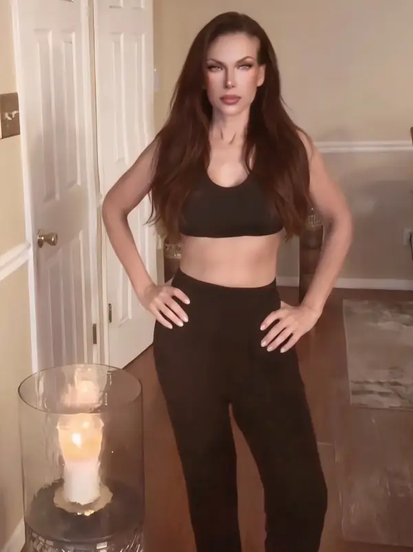 Janet Lubrano wearing black top and pants next to lit candles.